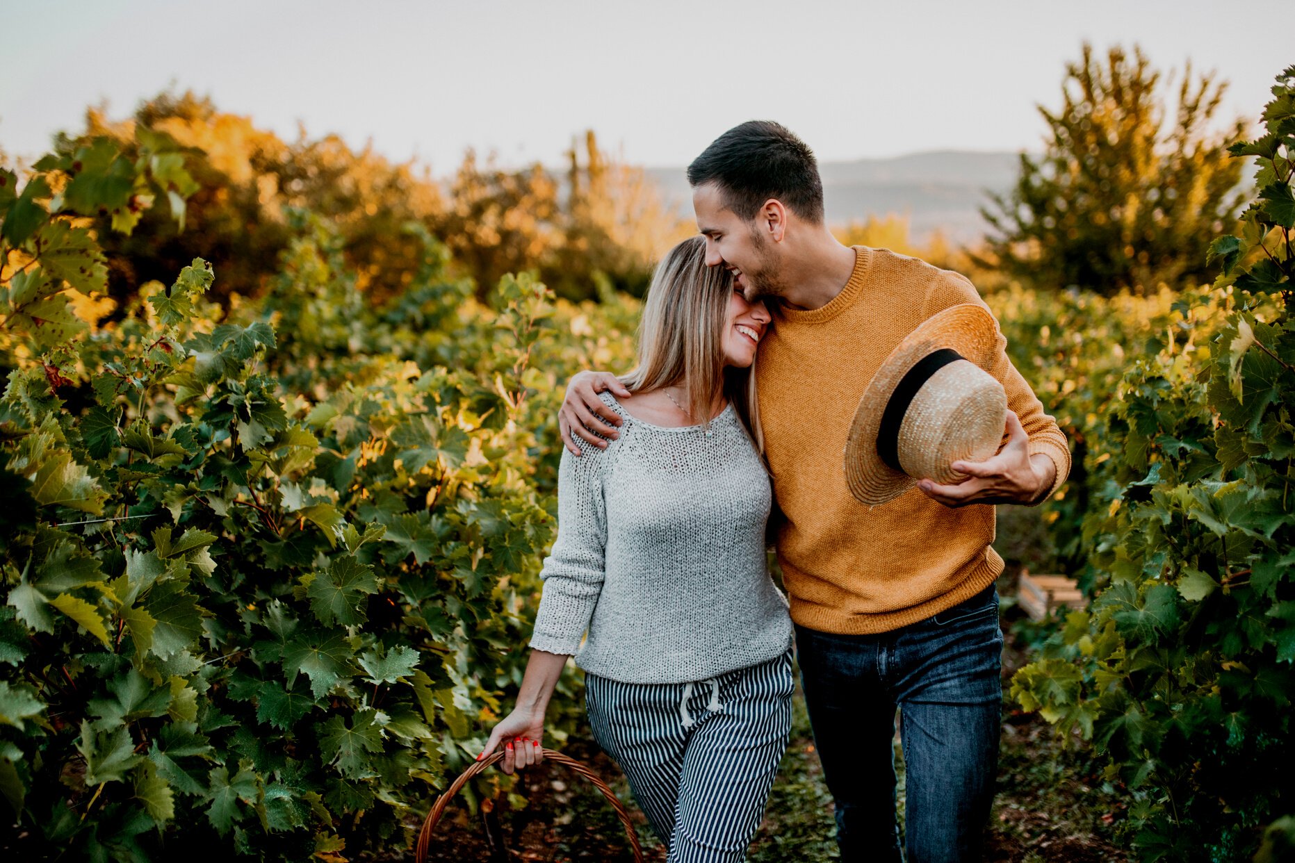 Happy couple walking through vineyard